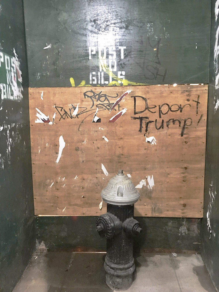 A fire hydrant enclosure provides an out-of-sight context for a nastily scripted political statement on public property, perhaps yearning for a hasty deportation before it's removed